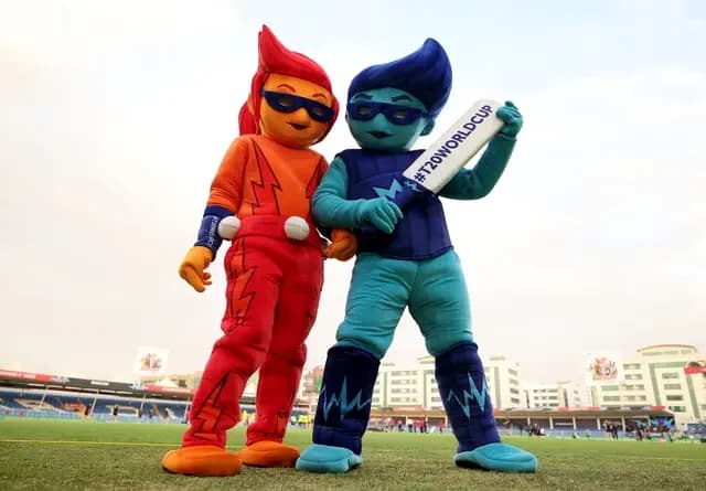 Two costumed tournament mascots posing together on the outfield
