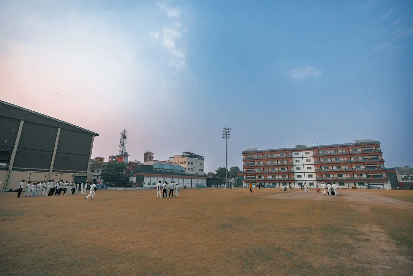 MS YTCA cricket players in whites gathered on the training ground before a session