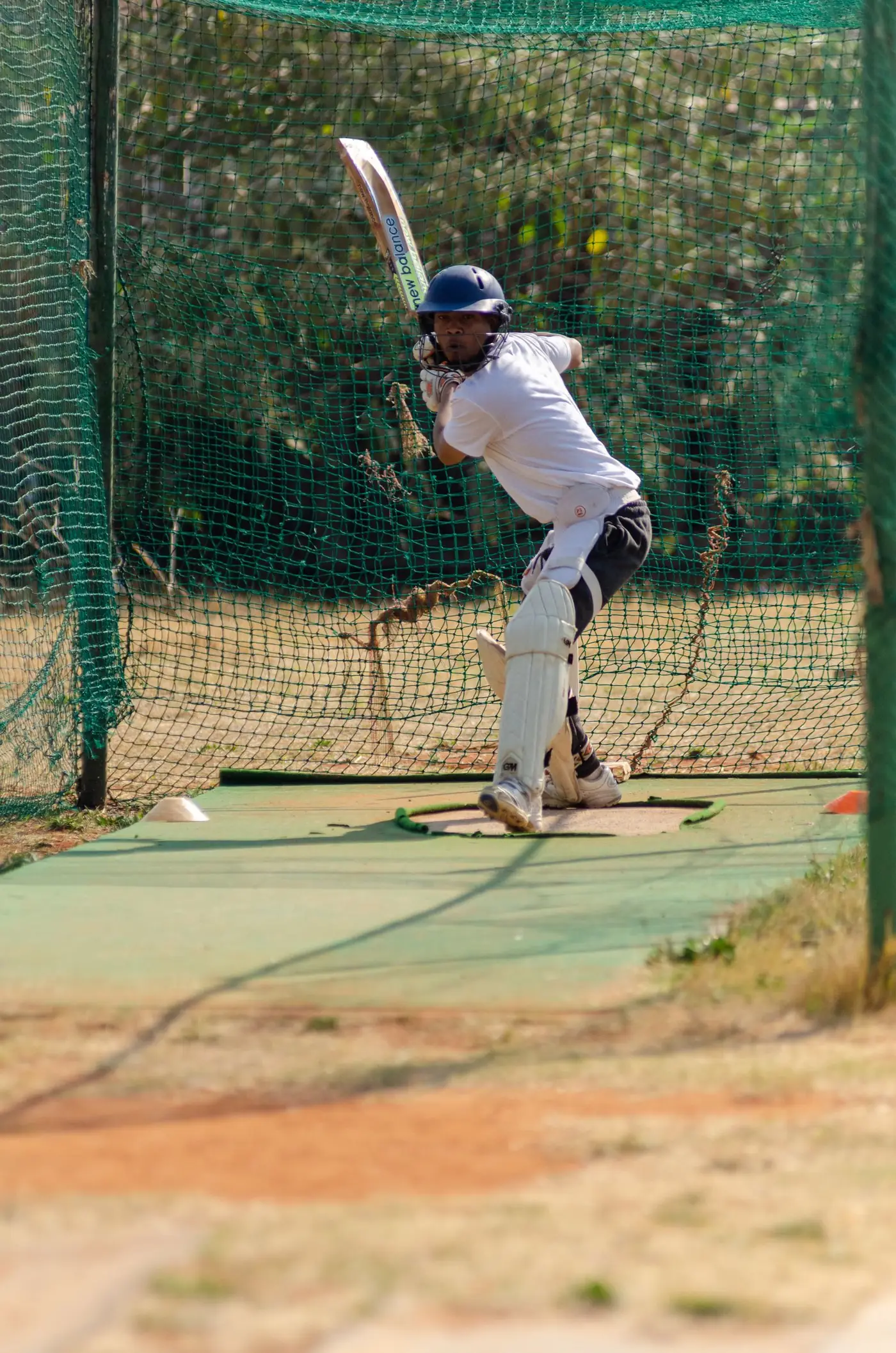 A young MS YTCA cricketer batting inside the practice nets