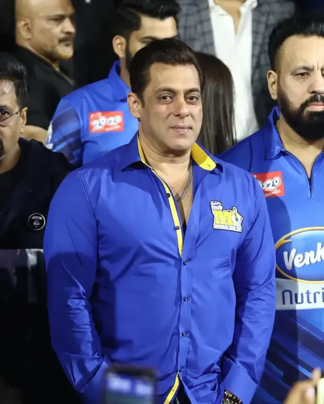 Bollywood actor greeting guests pitch-side at a cricket ground