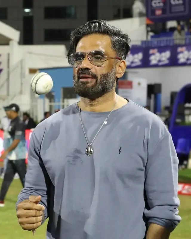 Bollywood actor tossing a cricket ball on the field